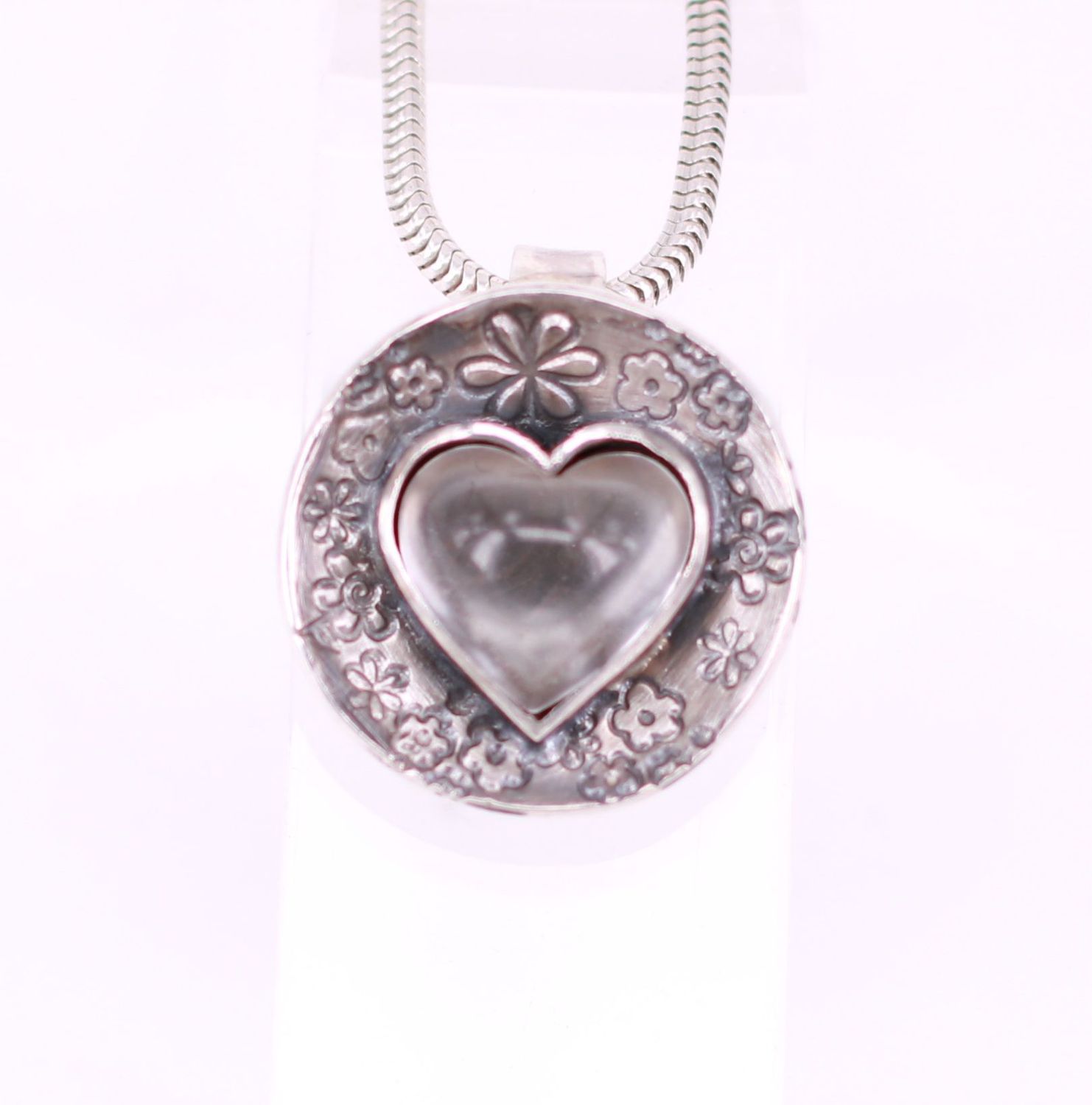 Bergkristallherz mit Schale und floraler Punzierung Bergkristall in Herzform mit blumendesign