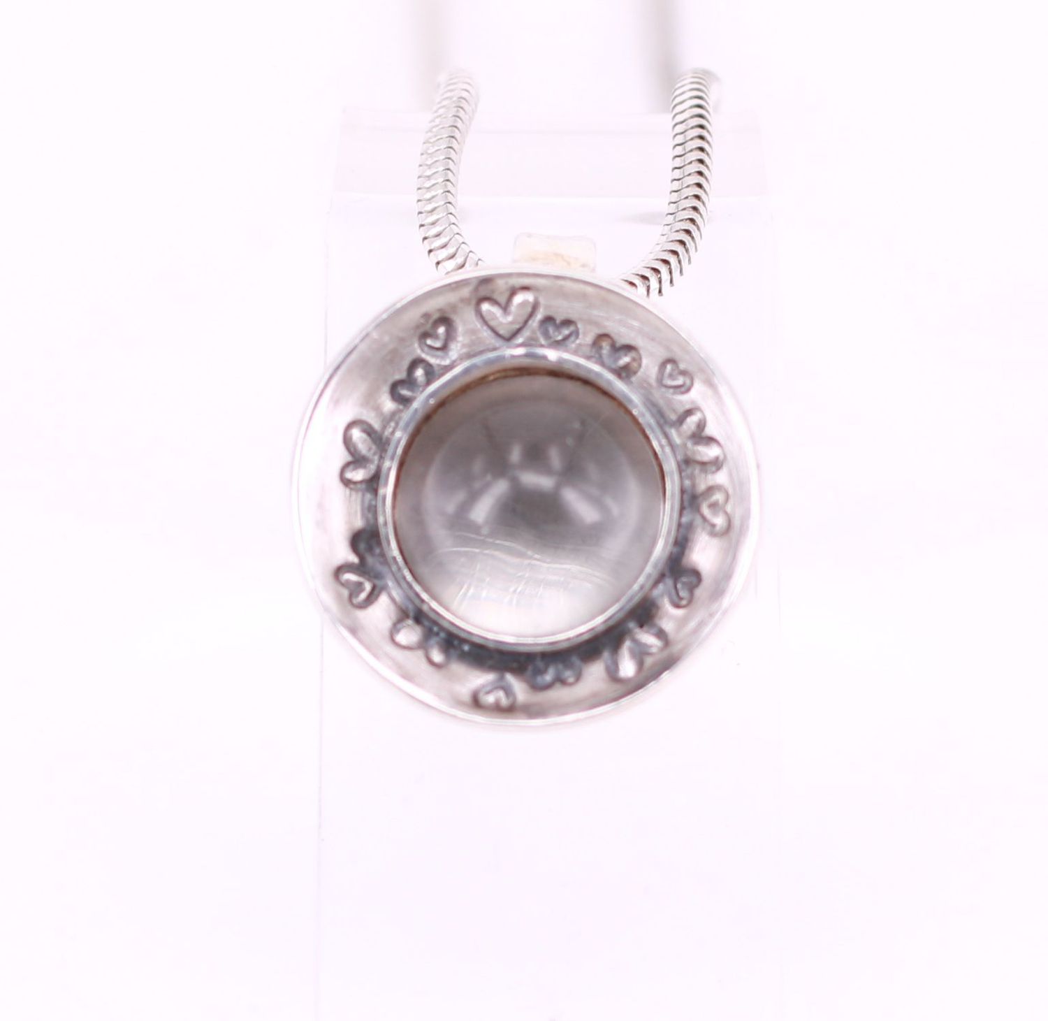 Runder Bergkristall in Schalenanhänger mit Herzen Tierhaare unter rundem Bergkristall in einer Herzschale