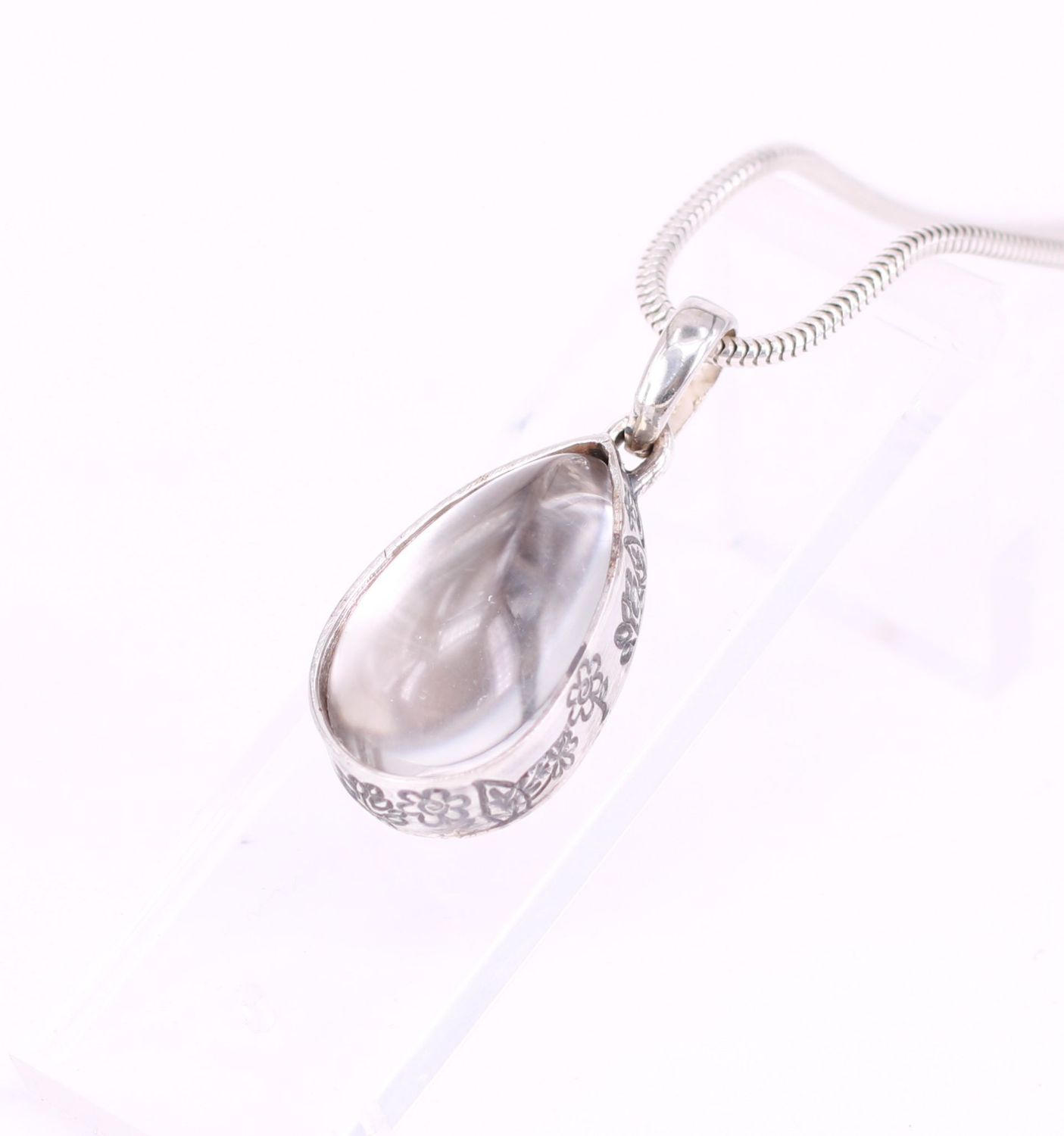 Tierhaarschmuck mit tropfenförmigem Bergkristall, Fassung mit floralen Elementen