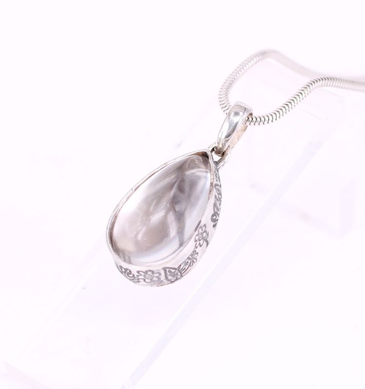 Tierhaarschmuck mit tropfenförmigem Bergkristall, Fassung mit floralen Elementen