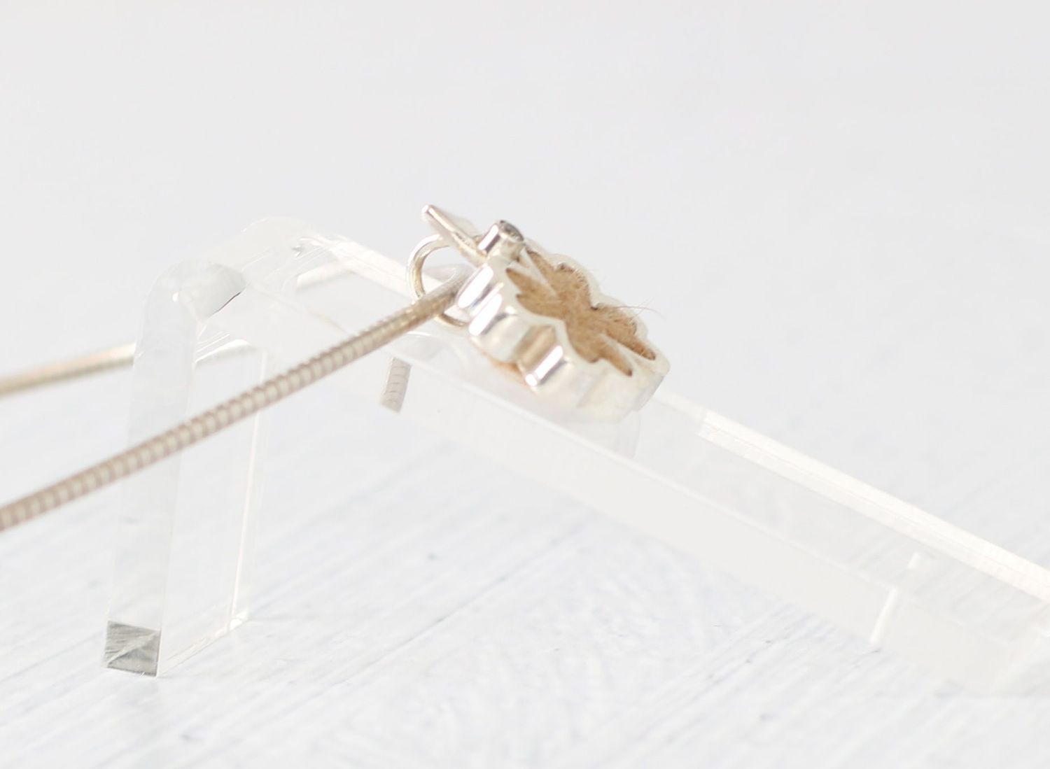 Kettenanhänger mit Tierhaaren in Kleeblattform mit facc. Edelstein