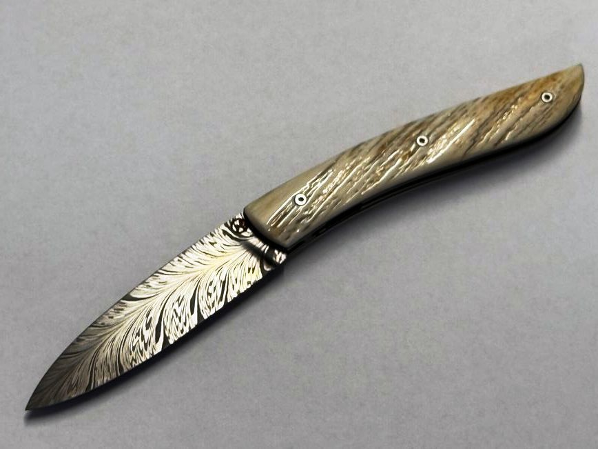 Couteau Névé von Tim Bernard, Griff Elfenbein vom Narwalzahn mit Saphirschrauben, Klinge 300 Lagen Feder-Damast, Ressort floral, Etui Haifischleder