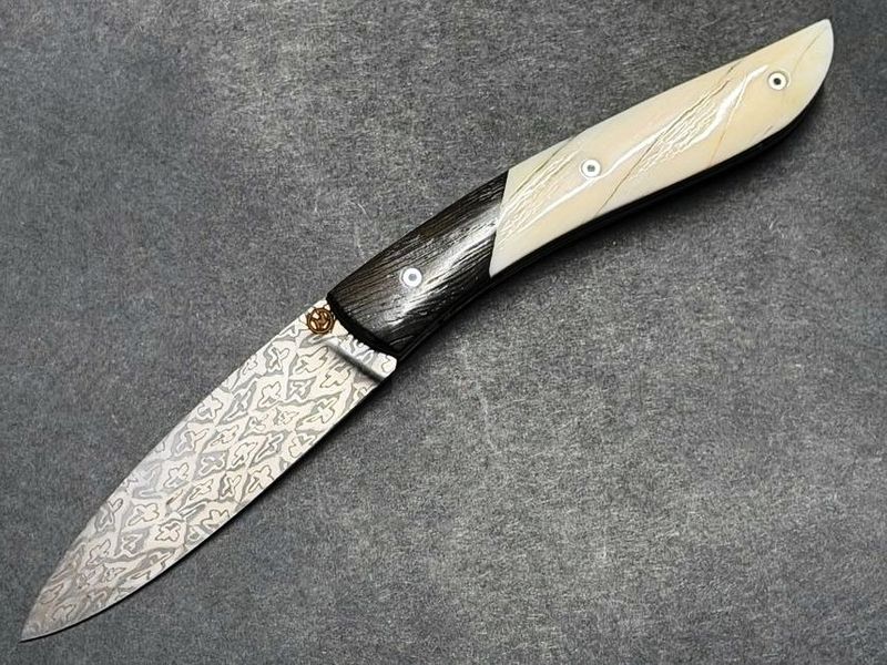 Couteau Névé von Tim Bernard, Griff Elfenbein vom Narwalzahn mit Saphirschrauben, Mitres aus fossiler Mooreiche, Klinge 300 Lagen Mosaikdamast,  Etui Haifischleder