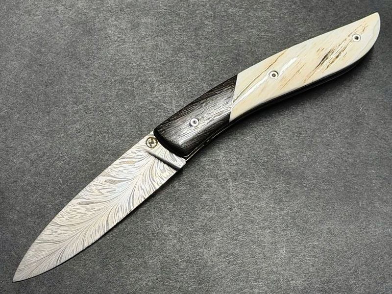 Couteau Névé von Tim Bernard, Griff Elfenbein vom Narwalzahn mit Saphirschrauben, Mitres aus fossiler Mooreiche, Klinge 300 Lagen Flammendamast, Etui Haifischleder, Messer Nr. 2