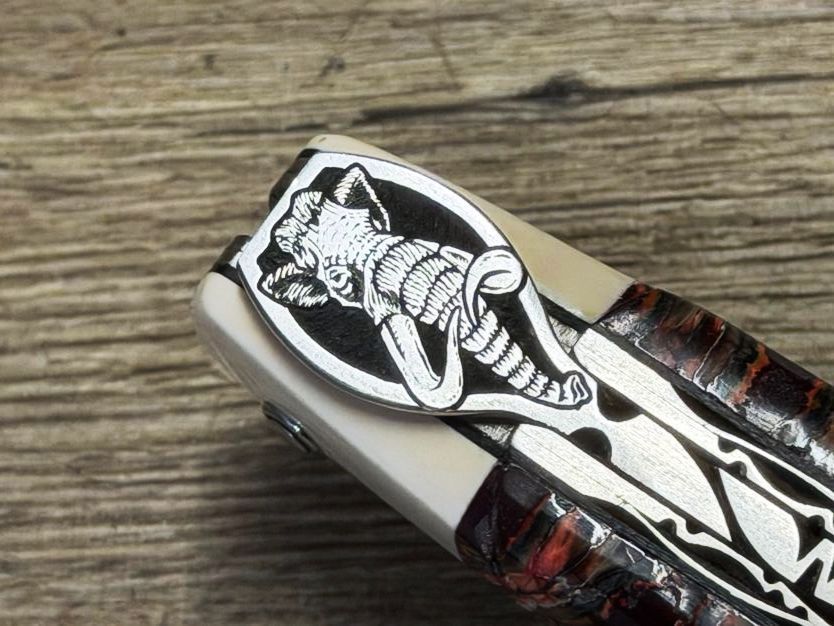 Meisterstück, Laguiole en Aubrac 12 cm, Doppelplatine, Griff Mammutbackenzahn rot/erdfarben mit Mammutelfenbeinmitres weiß, ziselierte Mouche Mammut, Balbach Damastklinge und Schlangenleder-Etui Meisterstück, Laguiole en Aubrac 12 cm, Doppelplatine, Griff Mammutbackenzahn rot/erdfarben mit Mammutelfenbeinmitres weiß, ziselierte Mouche Mammut, Balbach Damastklinge und Schlangenleder-Etui