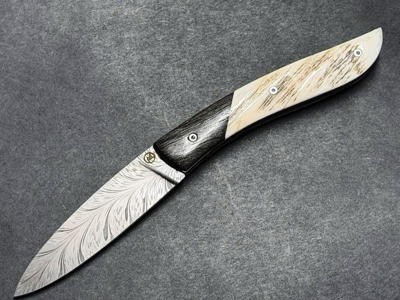 Couteau Névé von Tim Bernard, Griff Elfenbein vom Narwalzahn mit Saphirschrauben, Mitres aus fossiler Mooreiche, Klinge 300 Lagen Flammendamast, Etui Haifischleder, Messer Nr. 1 Couteau Névé von Tim Bernard, Griff Elfenbein vom Narwalzahn mit Saphirschrauben, Mitres aus fossiler Mooreiche, Klinge 300 Lagen Flammendamast, Etui Haifischleder, Messer Nr. 1