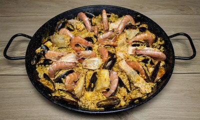 Paëlla aux fruits de mer garnie de moules, crevettes, calamars et poissons, prête à déguster