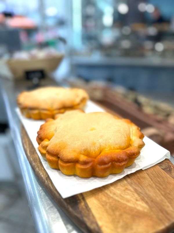 Tielle sétoise artisanale, tourte méditerranéenne garnie de poulpe à la sauce tomate épicée