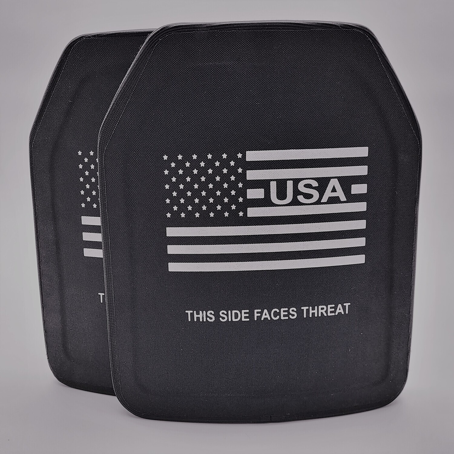 An oversized 11x14-inch Level IV ballistic armor plate designed to provide maximum protection against armor-piercing rifle rounds. The plate features a durable black exterior with a multi-curve shape for enhanced comfort and fit, ideal for larger body types. Clearly marked with &#39;THIS SIDE FACES THREAT&#39; and a white American flag graphic, this stand-alone plate is built for elite defense in high-threat tactical situations.