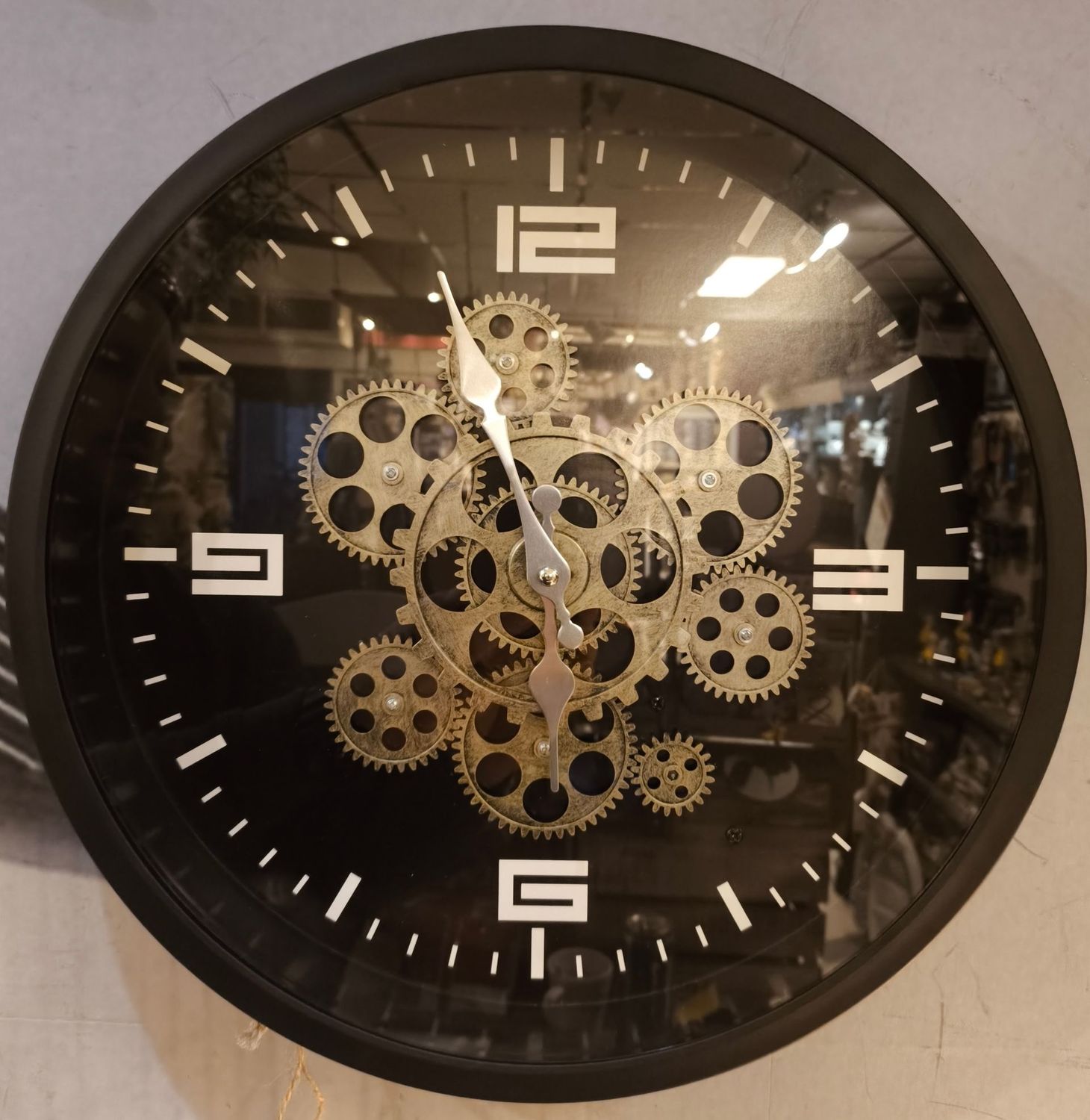 Wandklok zwart met gouden roterende tandwielen Wandklok zwart met gouden roterende tandwielen