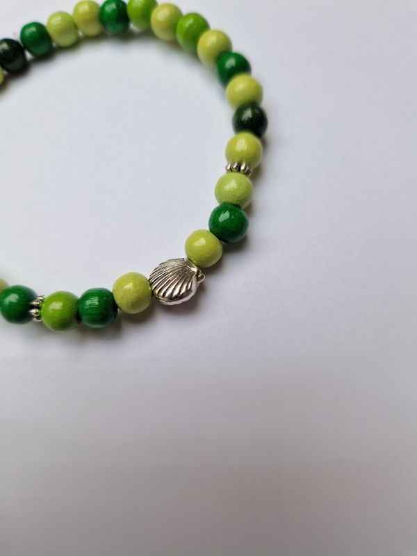 Armbandje met groene houten kralen en Jacobsschelp