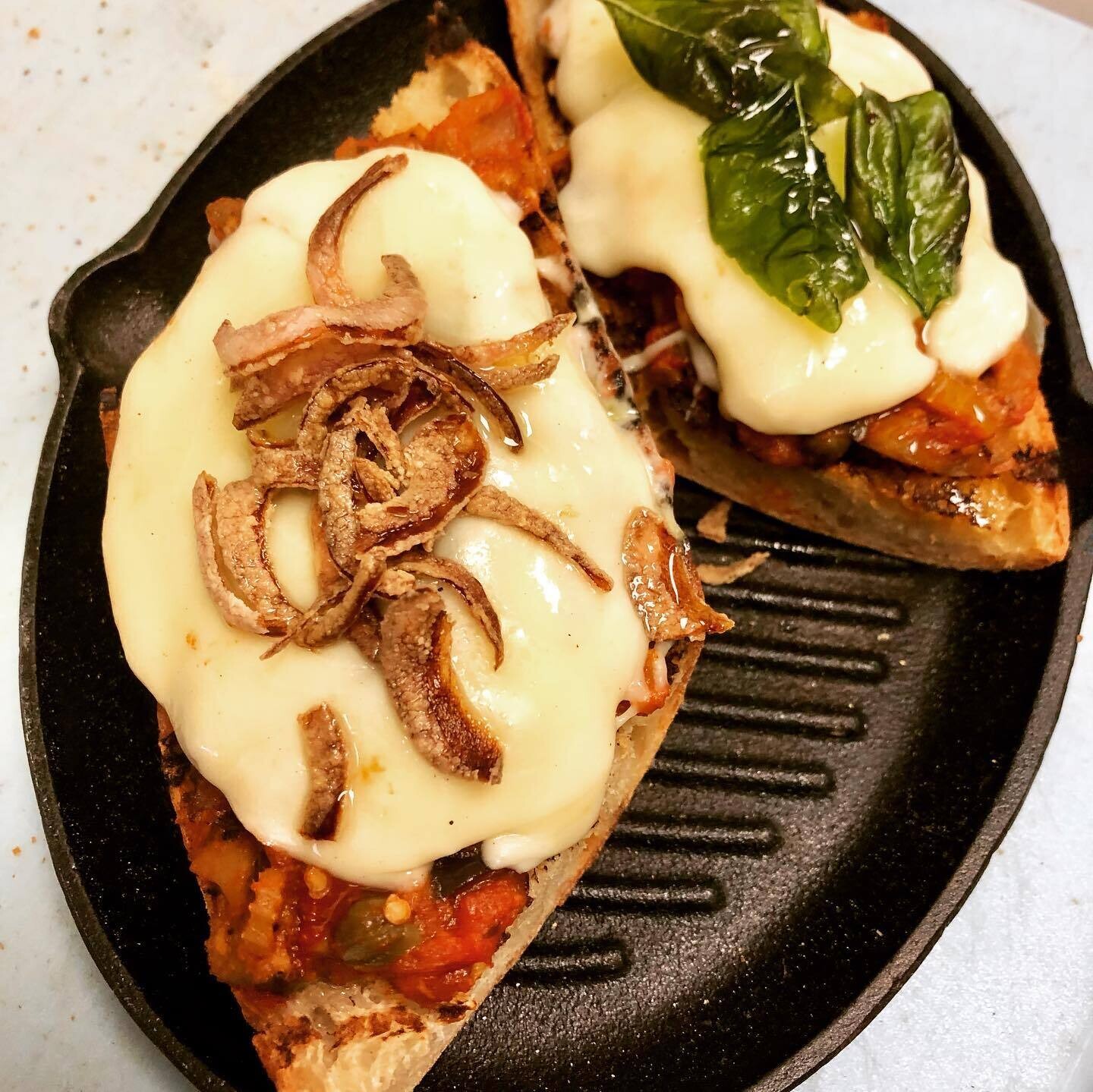 Open Face Caponata with Provolone and Crispy Pickled Onion/ Basil on a grilled Baguette 