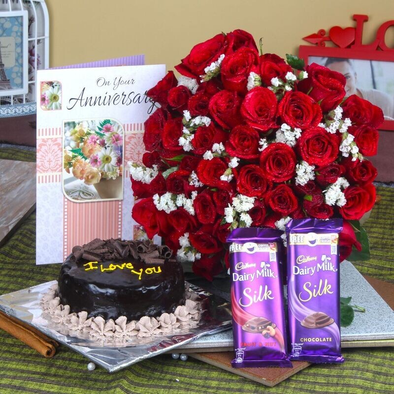 FIFTY RED ROSES HAND BUNCH AND ANNIVERSARY CAKE WITH CHOCOLATES