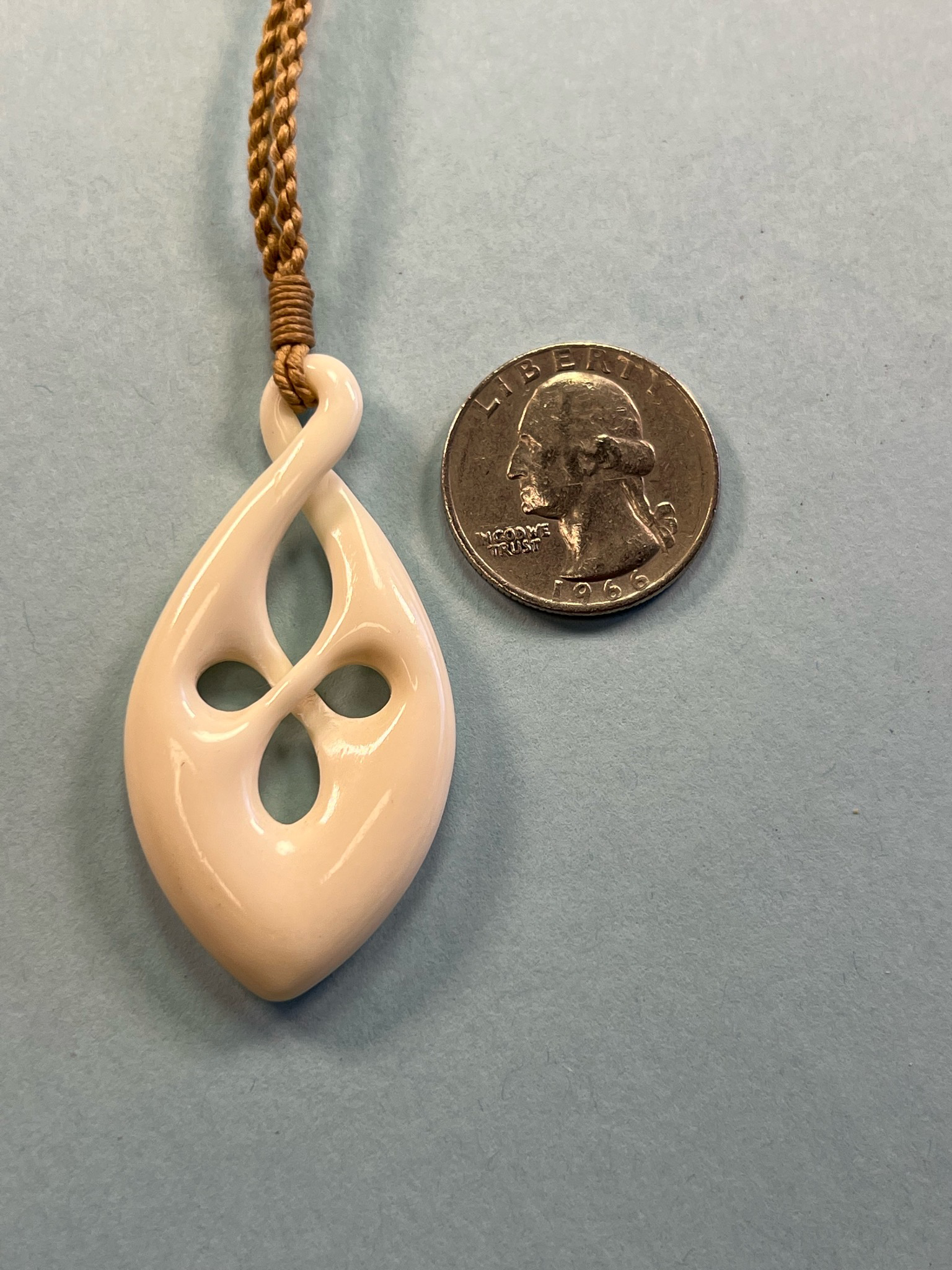 Carved Bone Māori Style Infinity Twist Knot Pendant on Adjustable Hand Braided Tan Cord.