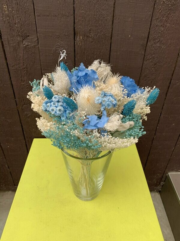 Groot blauw droogboeket in glazen vaas