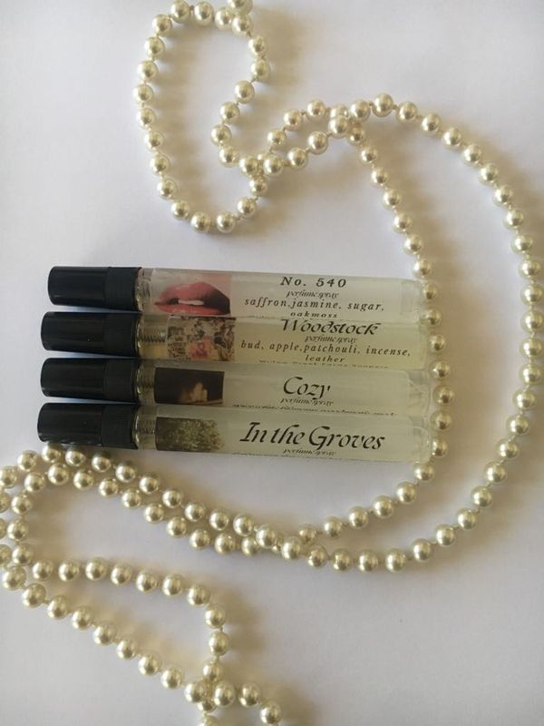 100 ml clear spray bottles (4) with black lids and perfume labels . There is a pearl strand wrapped around bottles