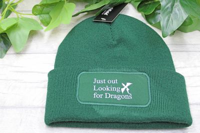 Flat lay of Just Out Looking for Dragons beanie on rustic wood