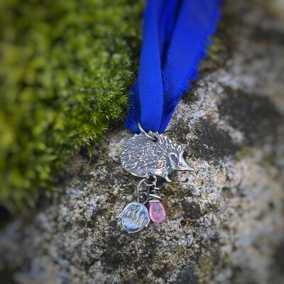 Hedgehog on Royal Blue ribbon pendant with silver hazelnut and pink sapphire.