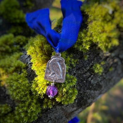 Raven ribbon pendant with carved amethyst bead.