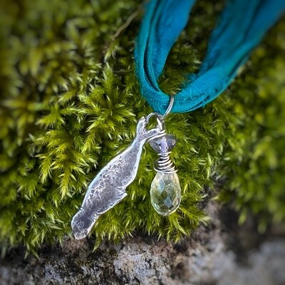 ​Selkie Seal pendant on turquoise green ribbon with iolite and phrenite gemstones.