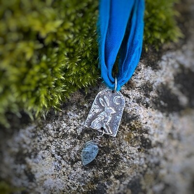 Hare ribbon pendant with carved aquamarine leaf.
