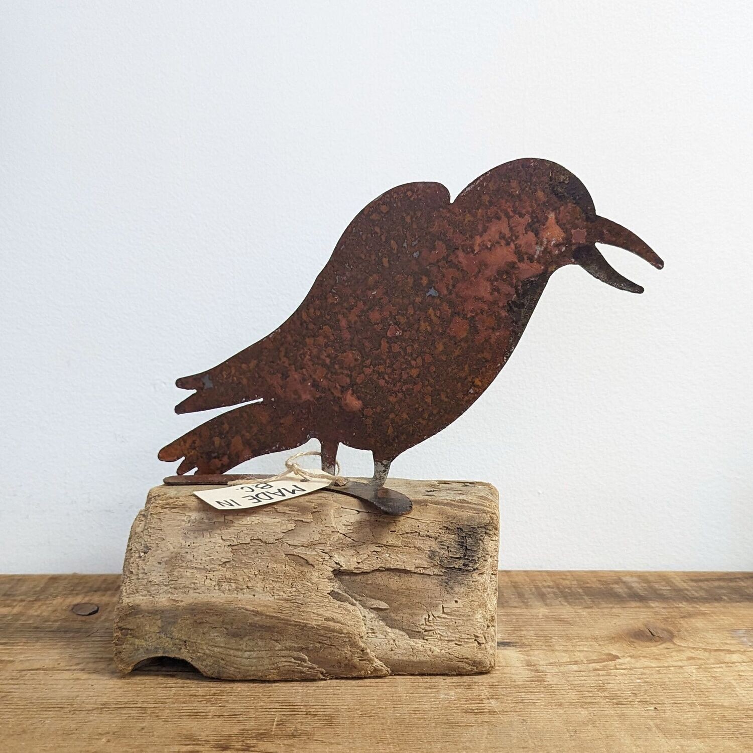Rusted Metal Crow On Driftwood