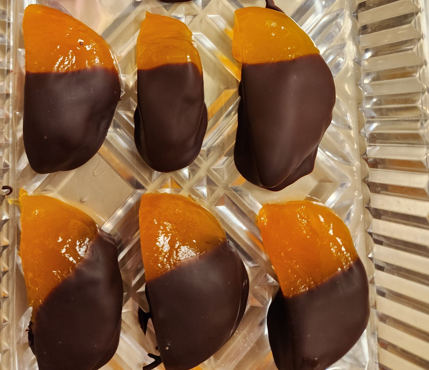 Glaceed peaches cut in half and half dipped in semi-sweet chocolate