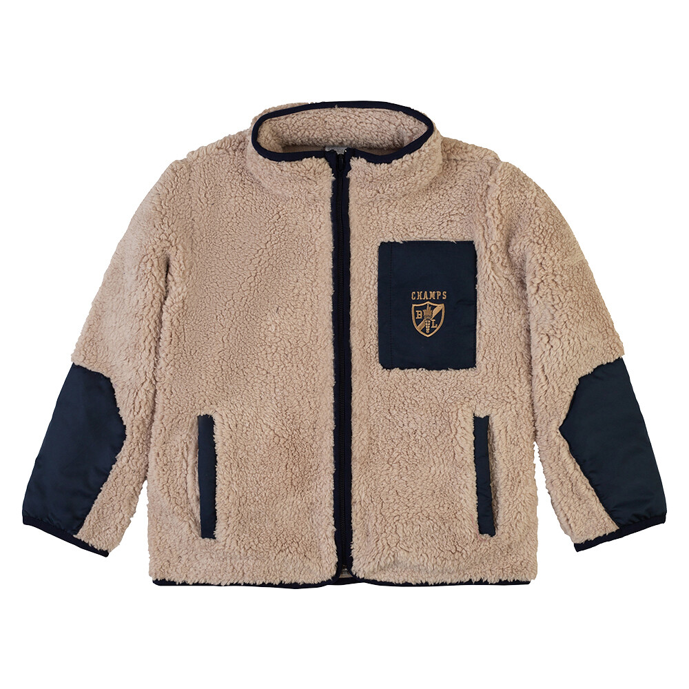 Jaquette en teddy polaire, couleur beige avec 2 poches à l'avant, et écusson champs sur fond marine