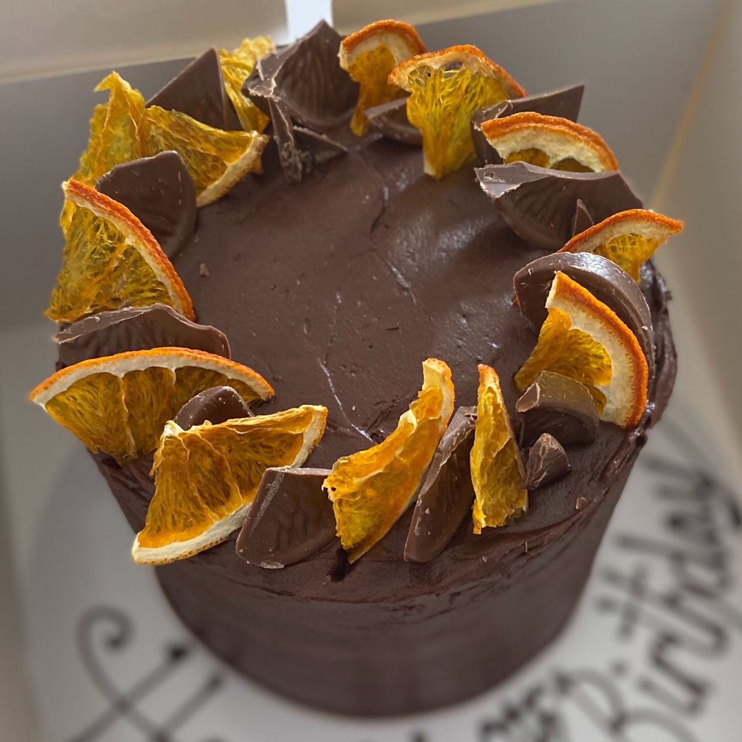 Chocolate orange - A nostalgic favourite, infused with natural orange zest in both sponge and icing, topped with candied orange slices and chocolate orange pieces.