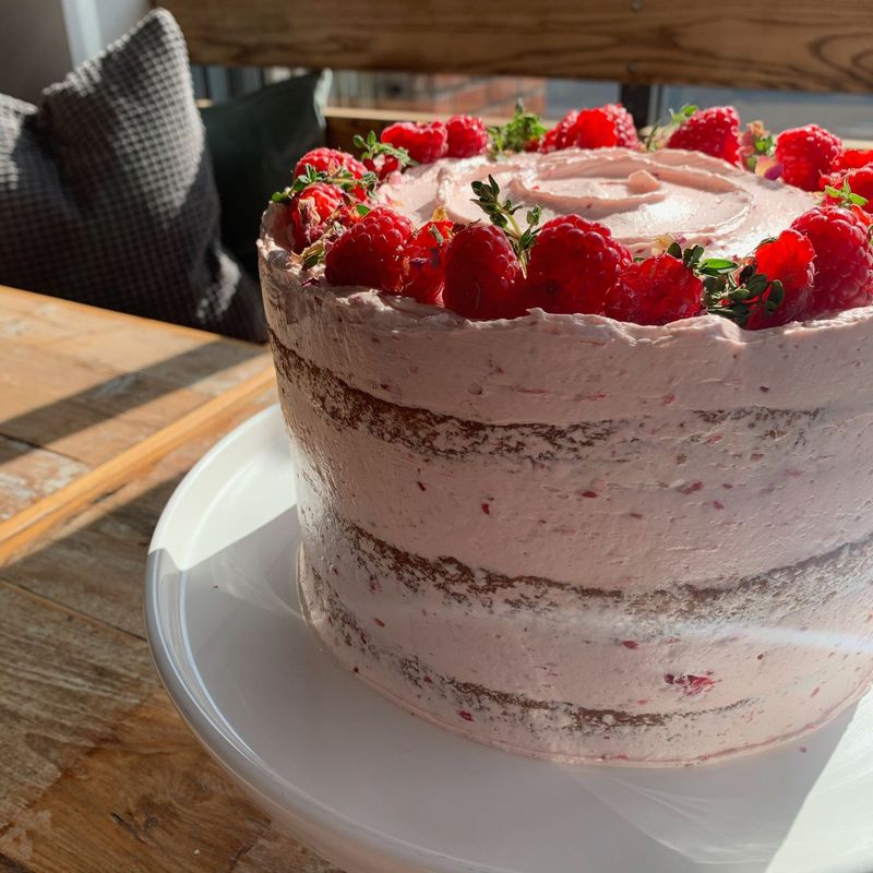 Lemon, Raspberry & Thyme - Bright, bold and beautiful– lemon and thyme drizzle sponge paired with house made raspberry jam and raspberry Swiss meringue buttercream. Topped with fresh raspberries and fragrant thyme for a fresh seasonal vibe.