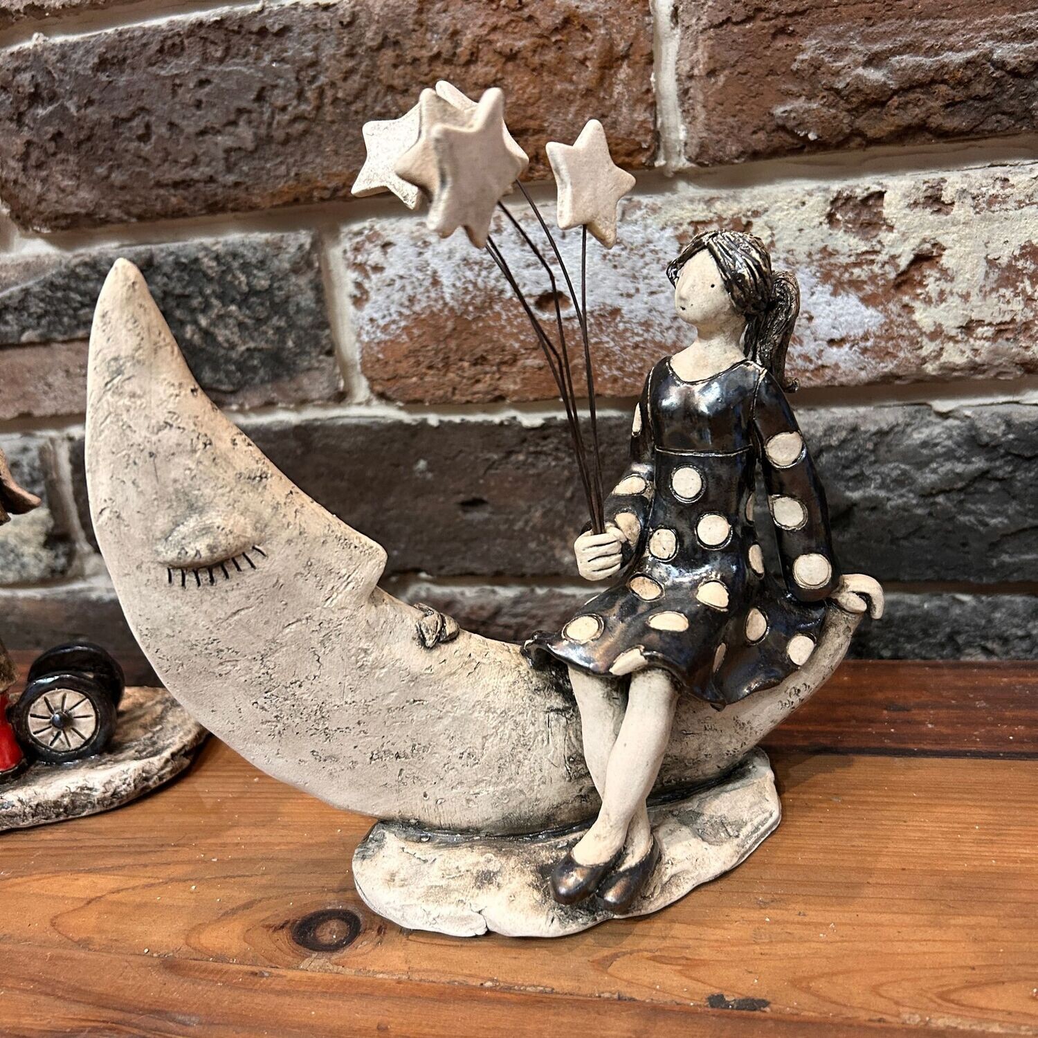 Scultura in ceramica ragazza sulla luna