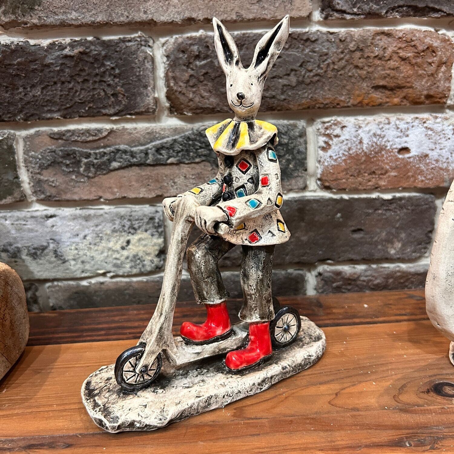 Scultura in ceramica coniglio su monopattino