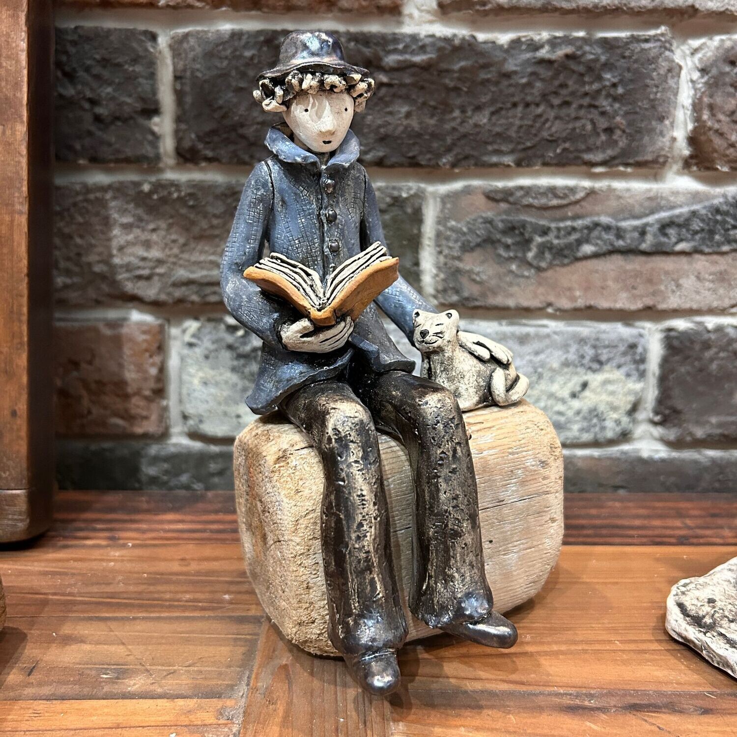 Scultura in ceramica ragazzo che legge con gatto