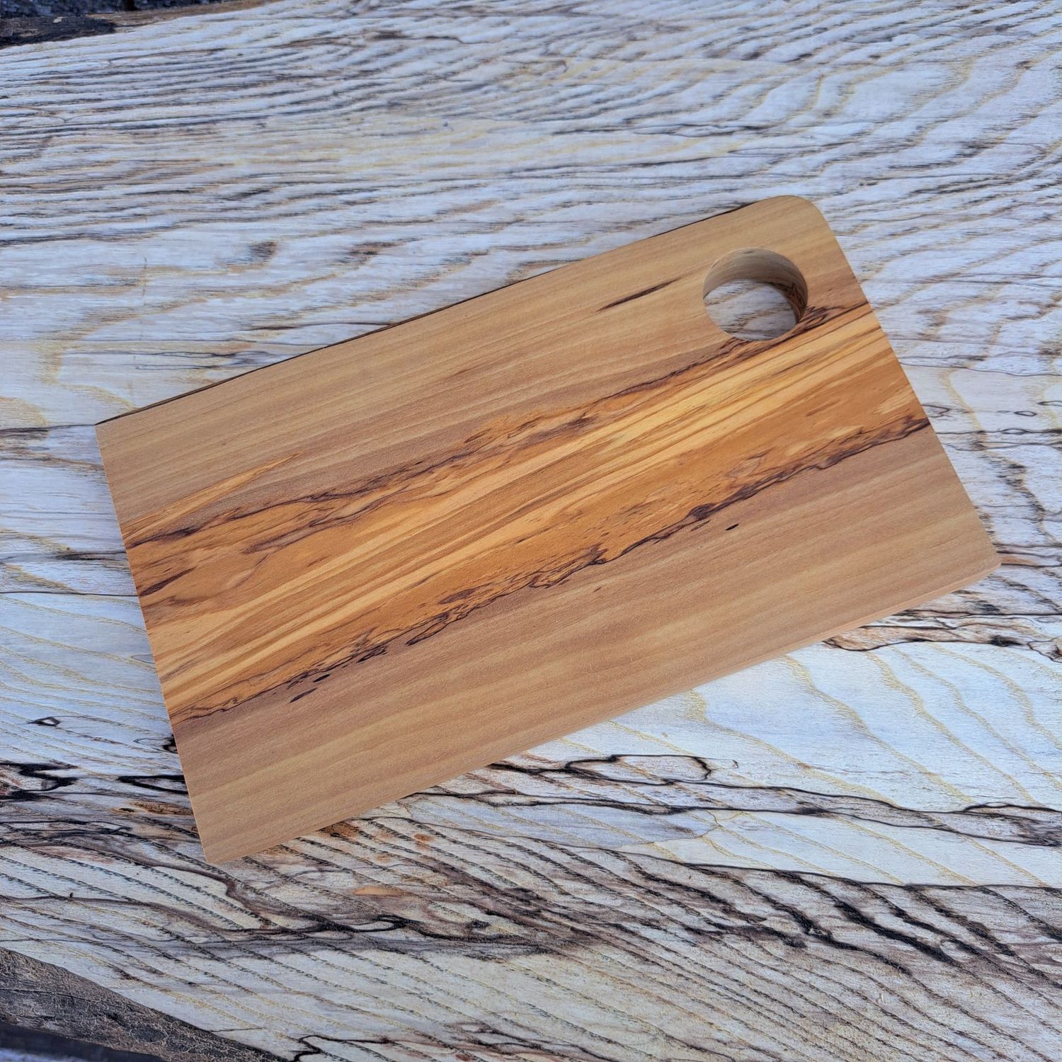 Olive wood chopping board Small wooden cutting board on a light wood background.