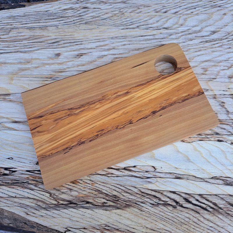 Small wooden cutting board on a light wood background.