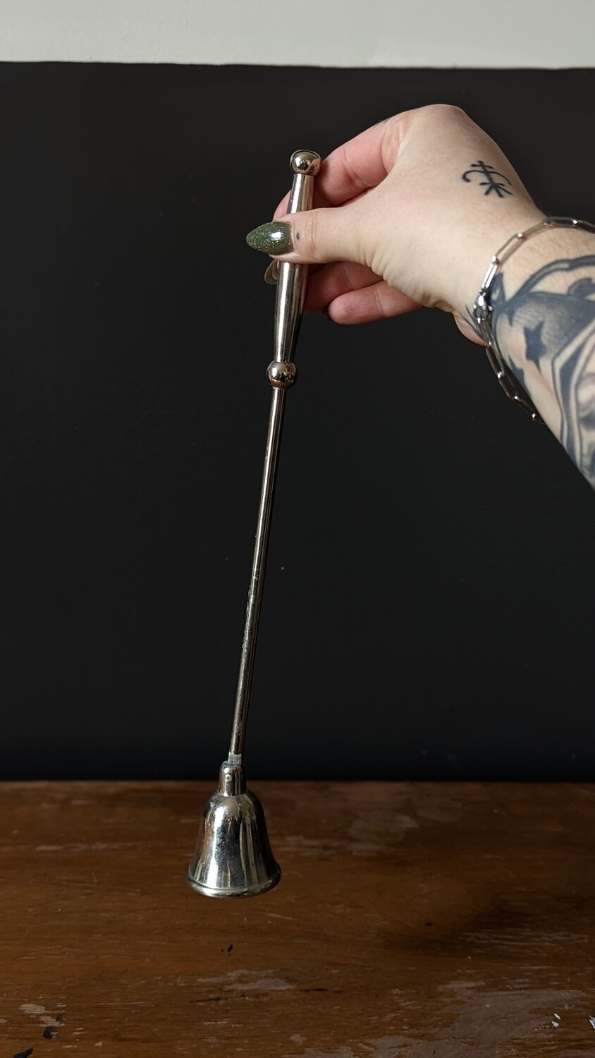 silver colored candle snuffer
