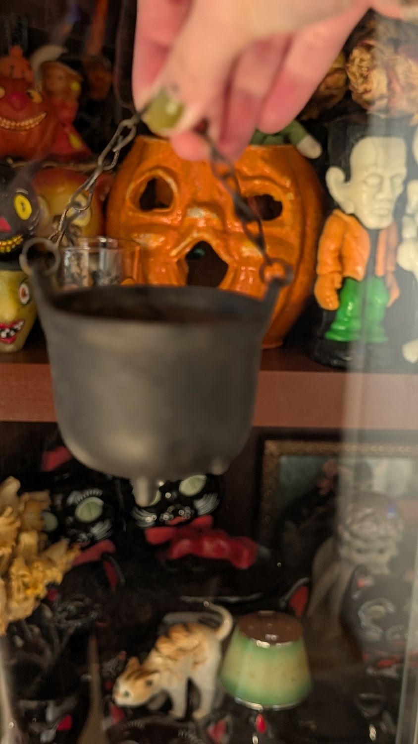 Small black cast iron cauldron with chain