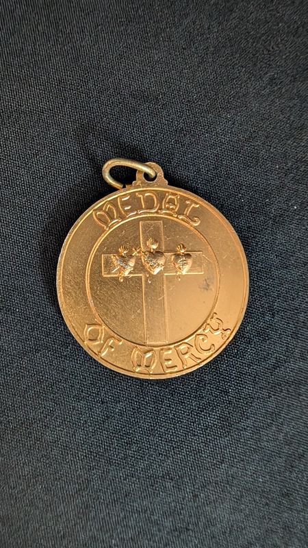 Gold colored religious medal of mercy - i am who am