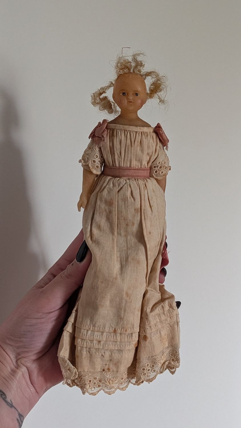 Very old doll with wax like face and blond hair