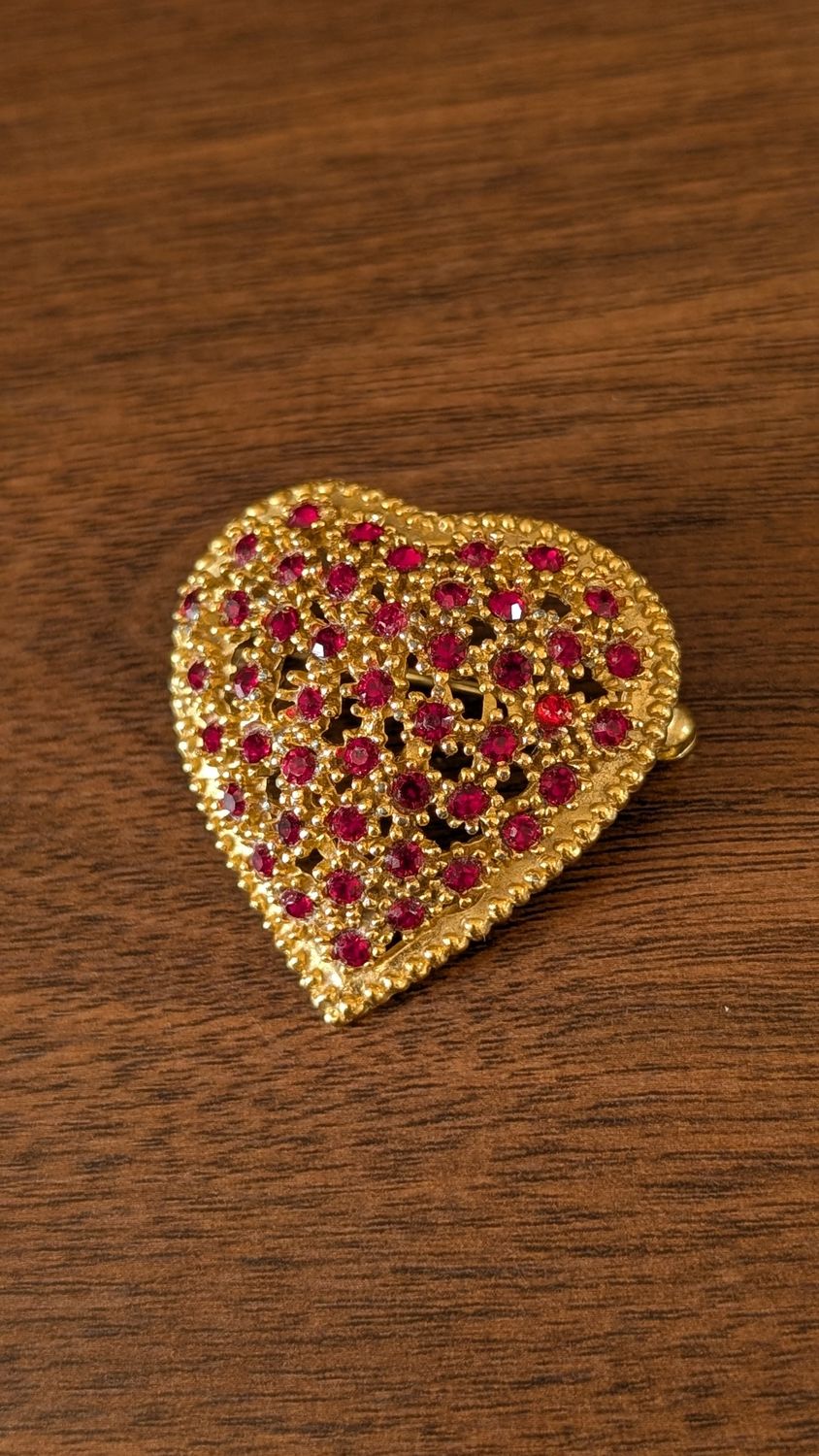 Golden heart brooch with small red gemstones