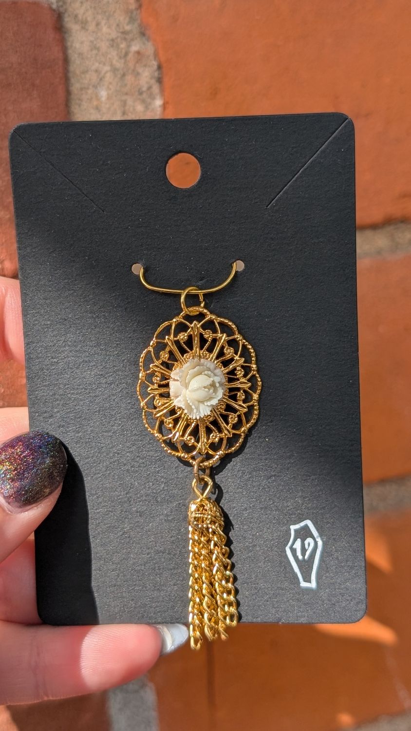 Gold tone ornate brooch with white rose