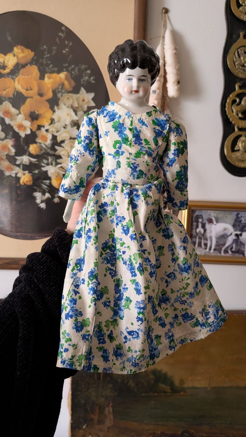 German hertwig china doll with colonial blue green floral dress black hair
