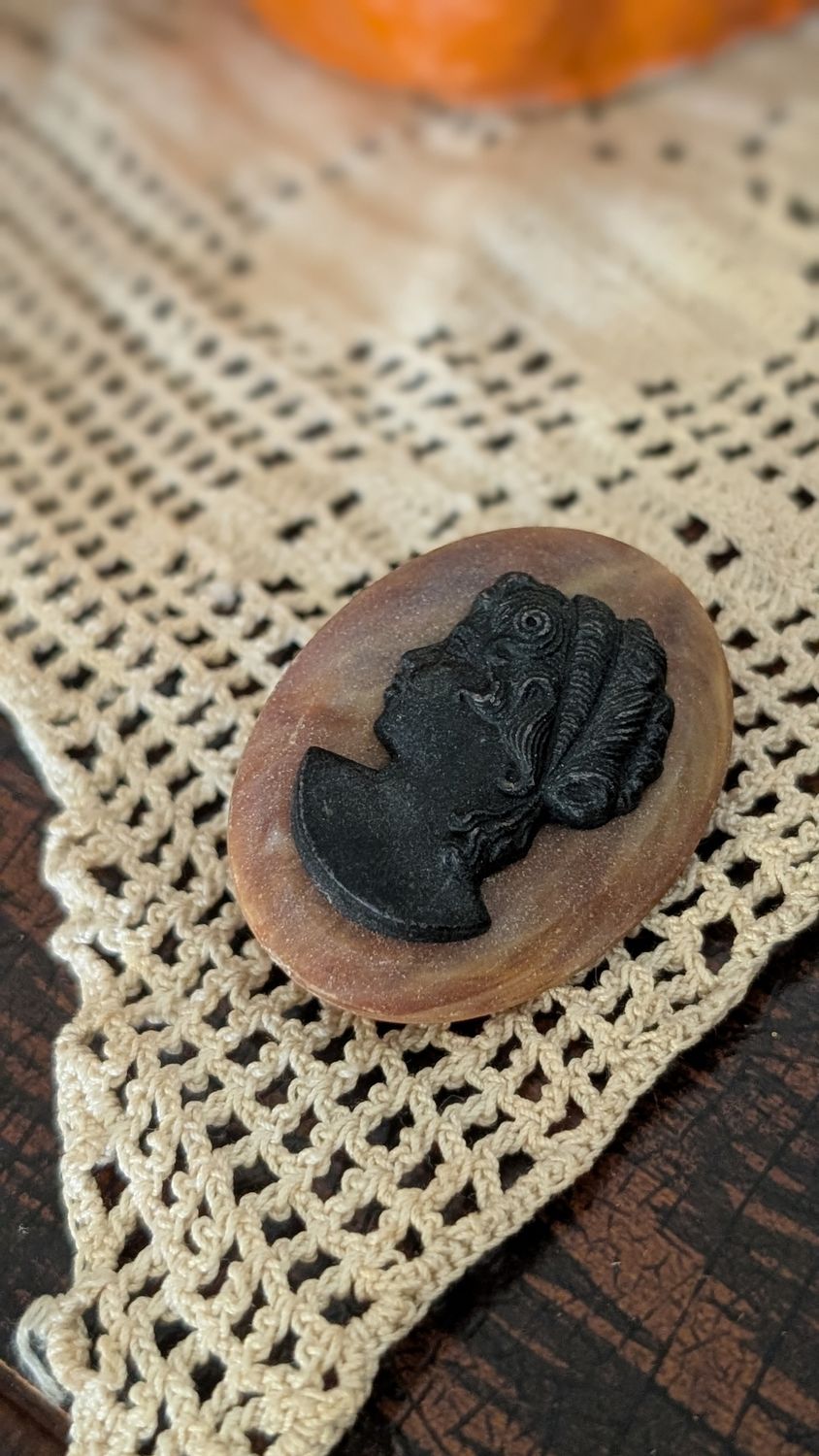 Black and dark orange plastic cameo brooch