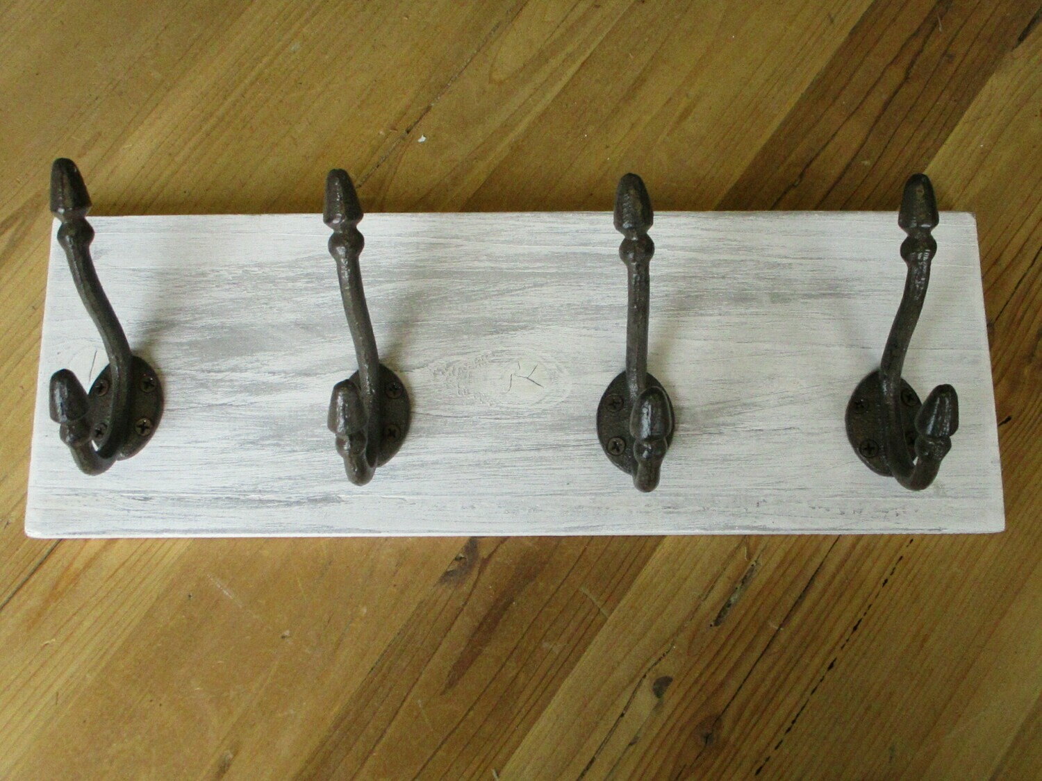 4 RUSTIC CAST IRON HOOKS ON DISTRESSED BACKING