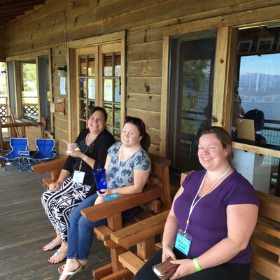 Three friends at Autumn JFO Camp sitting on benches overlooking Lake Tahoe.