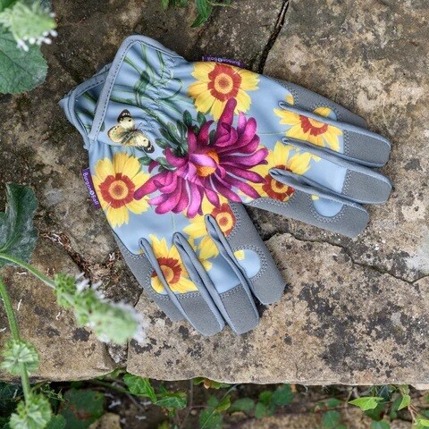 Asteraceae Design. Light Duck Egg Blue with three yellow flowers and one purple flower design.
Gardening Gloves featuring this design trimmed and palm area in grey.
Featured in garden wall.