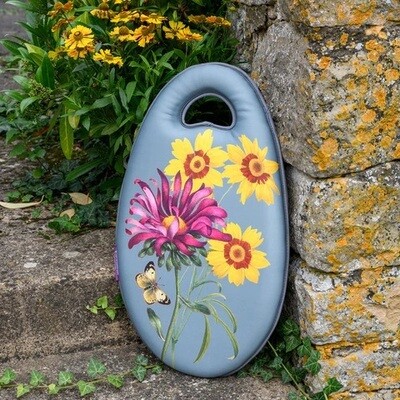 Asteraceae Design. Light Duck Egg Blue with three yellow flowers and one purple flower design.
Kneelo Kneeler - oval shape cushion with cut out handle
Set against a garden wall