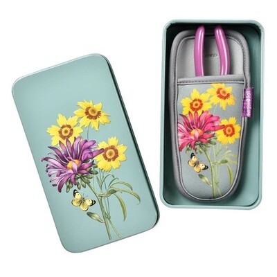 Asteraceae Design. Light Duck Egg Blue with three yellow flowers and one purple flower design.
Purpled handled pruner and holster featuring pattern and trimmed in grey. Gift box with pattern featured on lid.
Image of holster and pruners in tin with lid off.