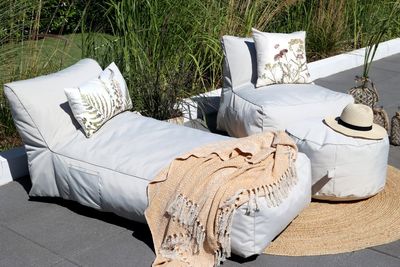 Beige Finish Soft Cushion Bed outside dressed with pillows and throws