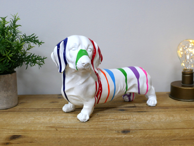 Don't you just love this little doggy. 
Made from resin in white finish but covered in stripes of all the colours of the rainbow. 
Front/ Side aspect close up image.
Height 12 cm